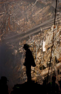 fireman standing with wreckage from 9/11 behind him. 