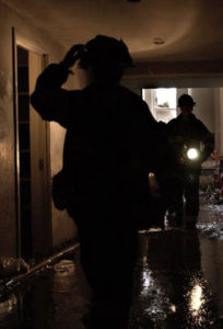 fireman walking through flooded hallway. 