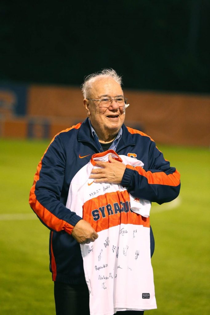 Alejandro Gracia holding autographed SU Soccer Jersey.