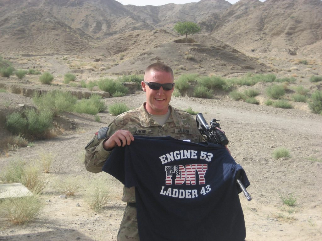 matthew coyne holding FDNY shirt.