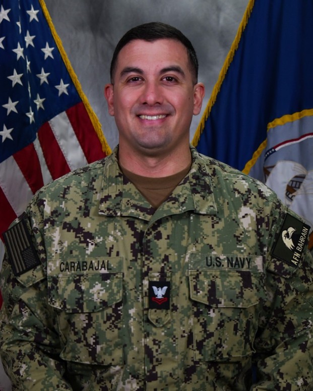 Joshua Carabajal in army military uniform posing for official photo in front of two flags