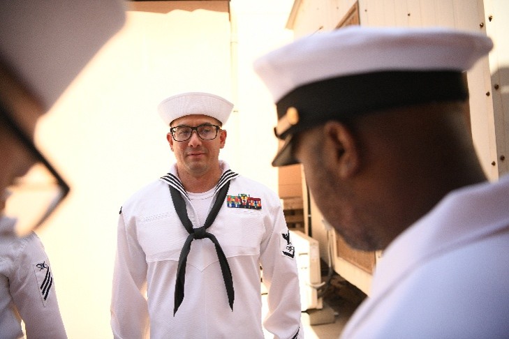 Joshua Carabajal in navy whites attending a stand-to meeting.